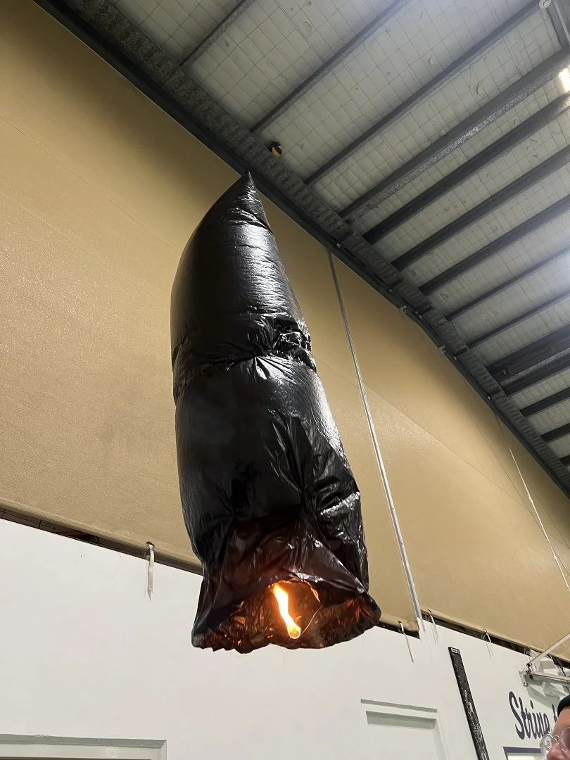 A student-built sky lantern inflated and lit during testing